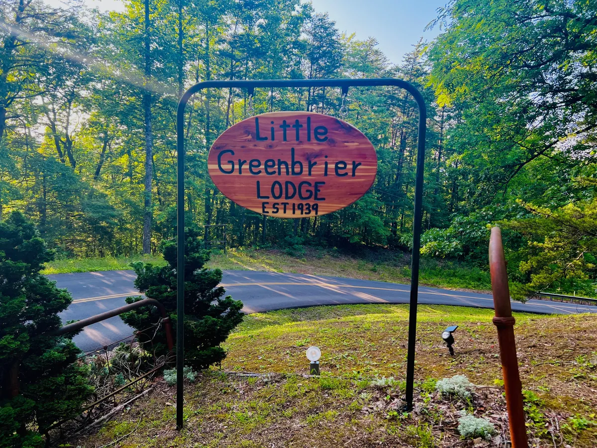 This image captures the signage of the lodge surrounded by greenery and a welcoming roadway, offering a sense of arrival and connection to the outdoors. The inviting scene suggests a place where families and guests gather before heading inside for entertainment or relaxation.