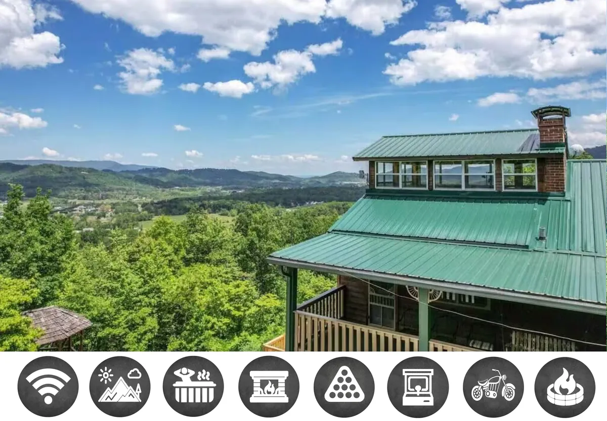The image showcases the impressive exterior of Little Greenbriar Lodge, highlighting its signature green roof and expansive wooden balcony overlooking the majestic Smoky Mountains. The serene natural setting suggests opportunities for relaxing on the balcony, watching sunsets, and savoring panoramic mountain views.